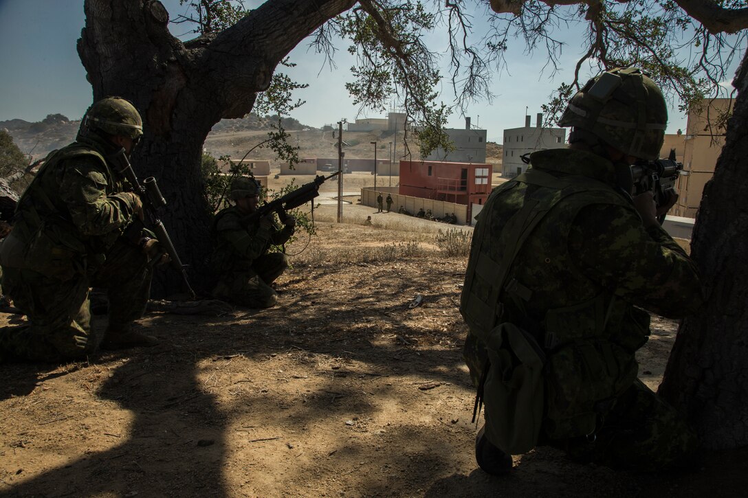 Canadian soldiers with the Royal 22e Régiment provide security during a simulated raid at a combat town as part of Rim of the Pacific (RIMPAC) exercise at Marine Corps Base Camp Pendleton, California, July 3, 2018. RIMPAC demonstrates the value of amphibious forces and provides high-value training for task-organized, highly-capable Marine Air-Ground Task Forces enhancing the critical crisis response capability of U.S. Marines in the Pacific. Twenty-five nations, 46 ships, five submarines, about 200 aircraft and 25,000 personnel are participating in RIMPAC from June 27 to Aug. 2 in and around the Hawaiian Islands and Southern California.