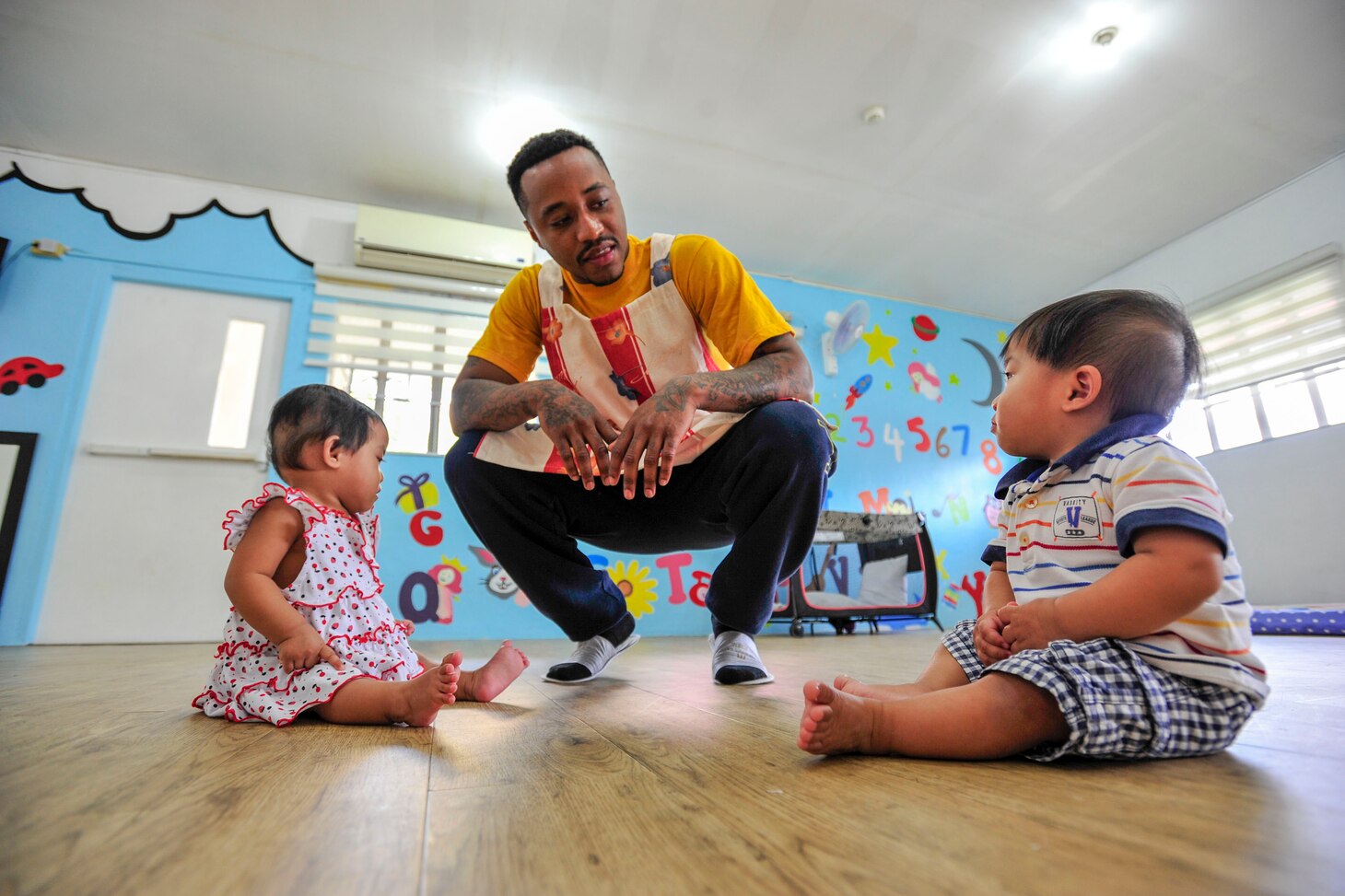 Aviation Boatswain's Mate (Fuel) Airman David Grant, from St. Louis, Missouri, assigned to the forward-deployed aircraft carrier, USS Ronald Reagan (CVN 76), plays with children during a community project at "A Home for the Angels," an orphanage dedicated to the rescue and nurturing of abandoned infants and toddlers. More than 200 Ronald Reagan Sailors participated in eight community projects sponsored by the ship's Command Religious Ministries Department during a scheduled port visit to Manila, June 26-30. Ronald Reagan, the flagship of Carrier Strike Group 5, provides a combat-ready force that protects and defends the collective maritime interests of its allies and partners in the Indo-Pacific region.
