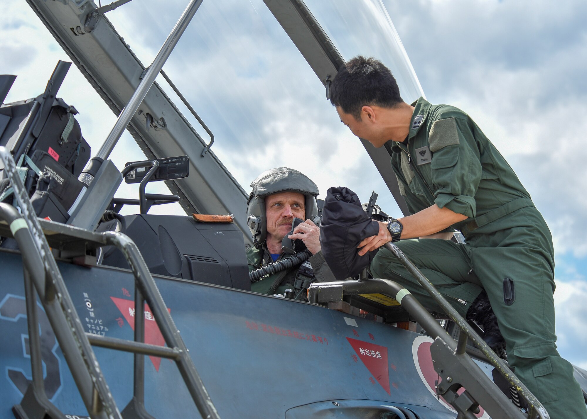 U.S. Air Force Col. R. Scott Jobe, the 35th Fighter Wing commander, speaks with Japan Air Self-Defense Force 1st Lt. Yoshinobu Sasaki, a 3rd Air Wing F-2 pilot, before a familiarization flight at Misawa Air Base, Japan, June 22, 2018. The flight gave Jobe, an F-16 Fighting Falcon pilot, the opportunity to experience the Mitsubishi  F-2 mission set. (U.S. Air Force photo by Airman 1st Class Collette Brooks)