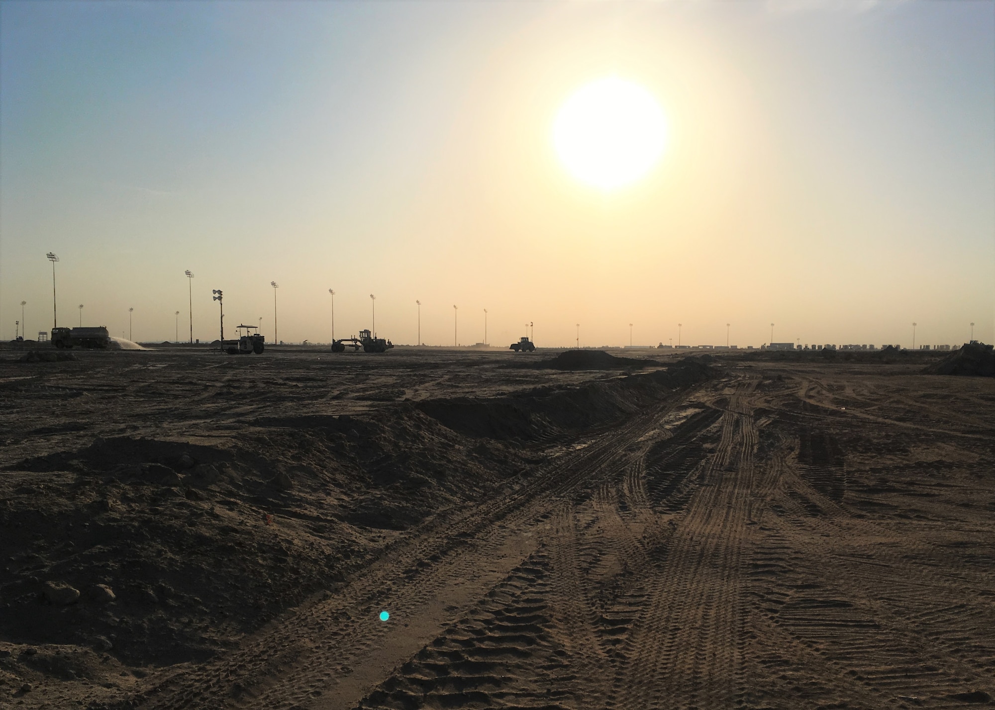A day of back-filling comes to an end at Cargo City, on Kuwait International Airport, Kuwait, December 18, 2017. Before building the future Aerial Port of Debarkation, the 386th Expeditionary Civil Engineer Squadron, 1st Expeditionary Civil Engineer Group, 387th Expeditionary Support Squadron had to make the site suitable for construction. (Courtesy photo)