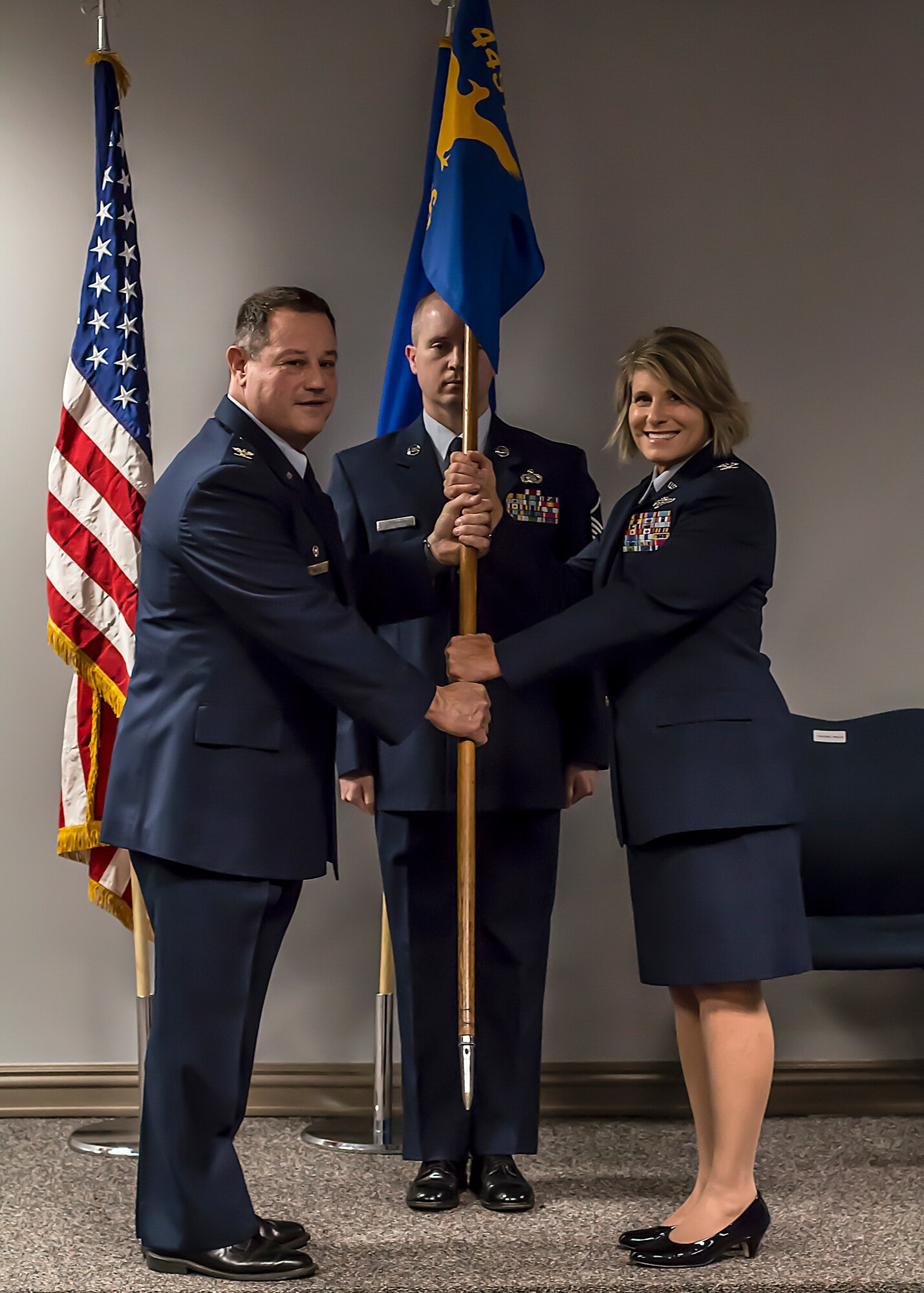 Col. Adam Willis, 445th Airlift Wing commander, passes the guidon to Col. Roberta Stemen, incoming 445th Aeromedical Staging Squadron commander, during an assumption of command ceremony June 2, 2018.