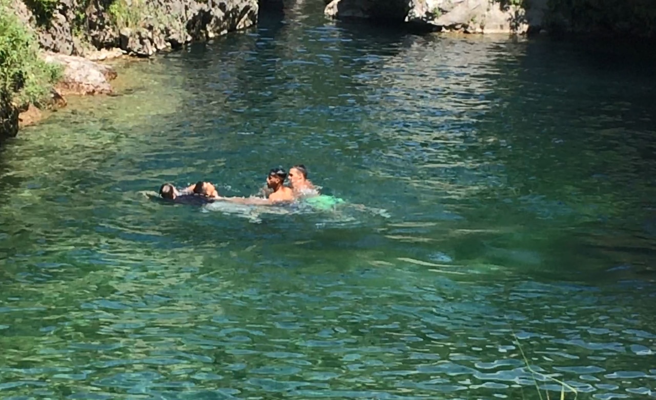 Three men help a drowning man.
