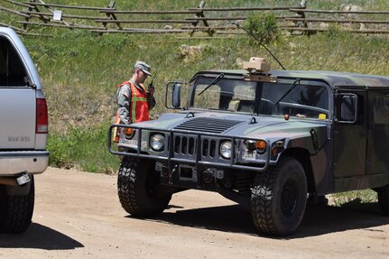 Colorado Army National Guardsmen, Private Joshua Breeden, radios higher authorities for an authorization tp pass for a civilian traveling through a road closer. Breeden is a member of Task Force Security assisting Boulder County Sheriff's Office with Cold Springs fire relief efforts in Boulder Colo., July 11, 2016.