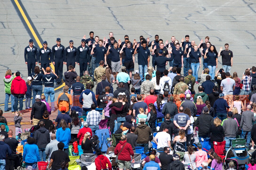 Spectators watch as new Air Force recruits participate in an enlistment ceremony.