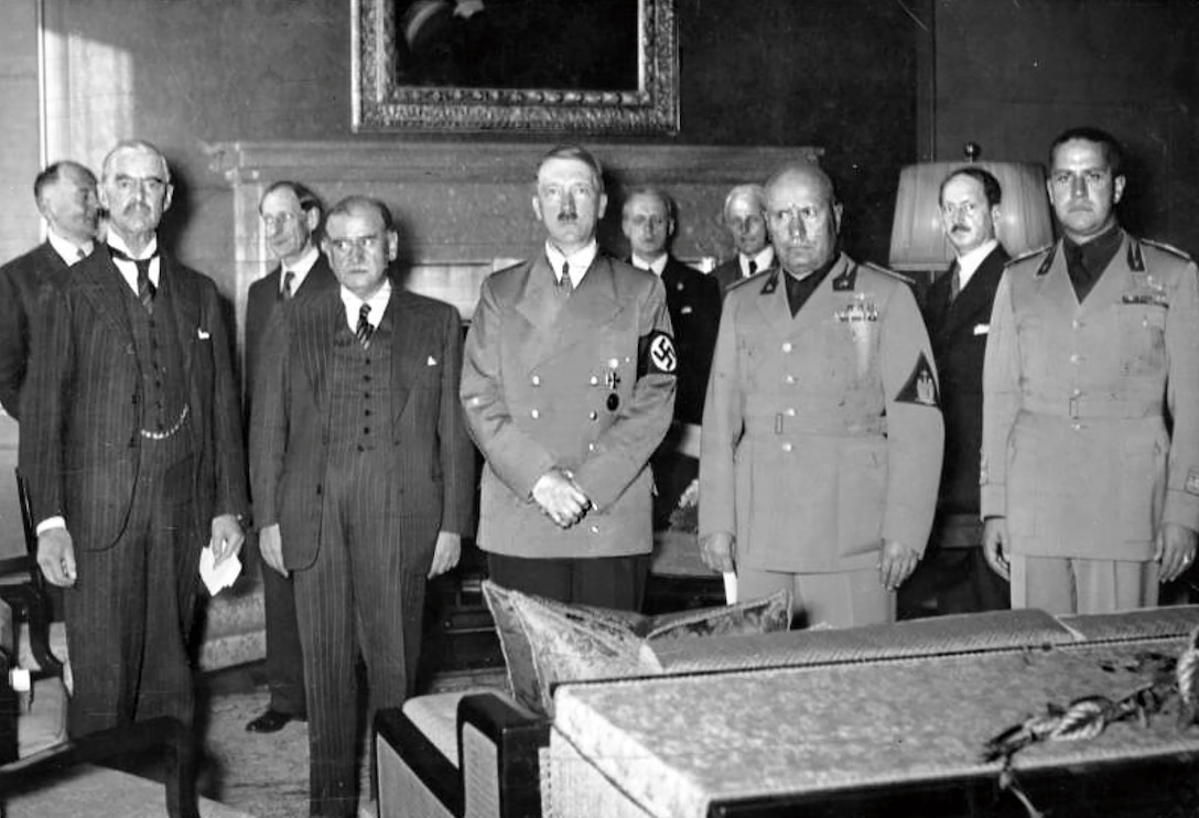 Front row, left to right, British Prime Minister (PM) Neville Chamberlain, French PM Édouard Daladier, German Chancellor Adolf Hitler, Italian PM Benito Mussolini, and Italian Foreign Minister Count Ciano as they prepare to sign Munich Agreement, September 29, 1938 (Courtesy German Federal Archive)