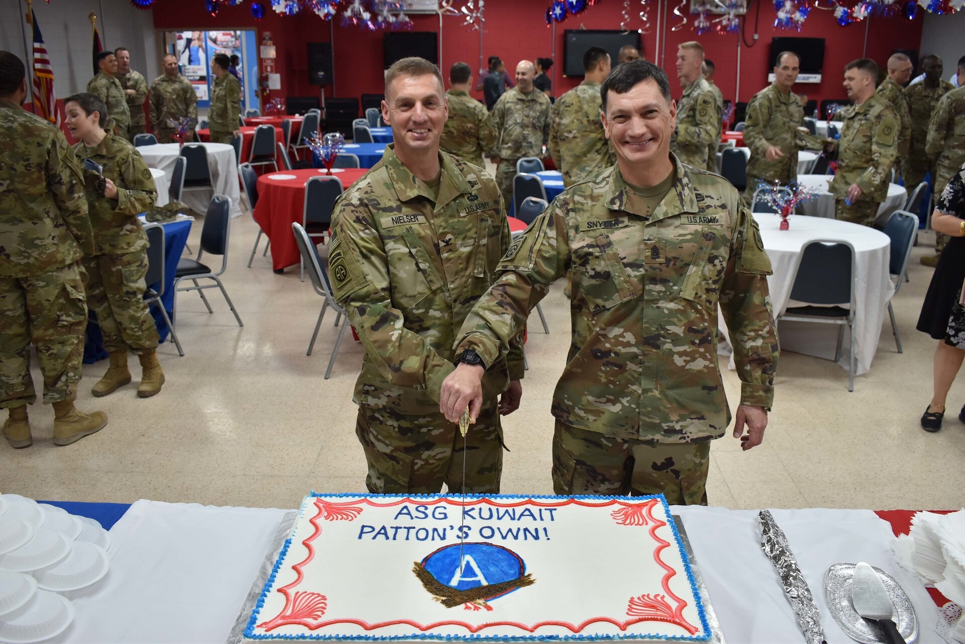Col. Shannon Nielsen and Command Sgt. Maj. William Synder cut the ceremonial cake after the Area Support Group-Kuwait Change of Command on July 2, 2018 at Camp Arifjan, Kuwait.