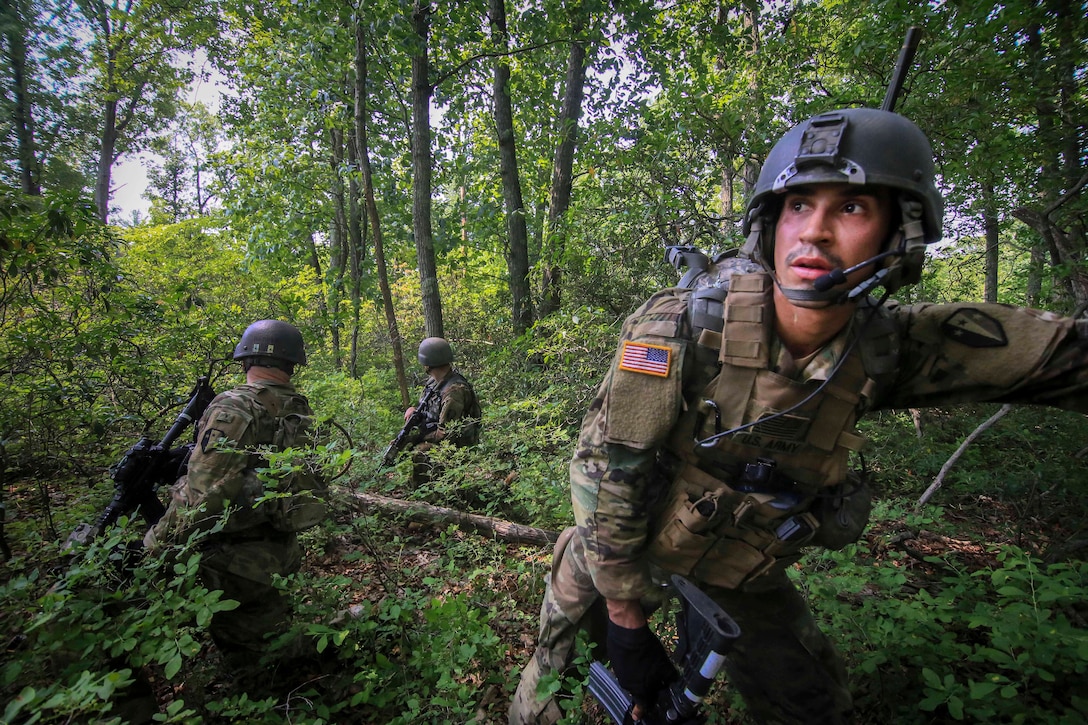 Soldiers move tactically through the woods to their follow-on objective.