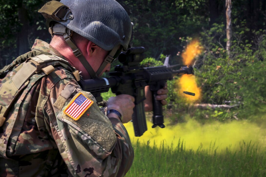 A soldier returns fire with his M4 Carbine at opposing forces.