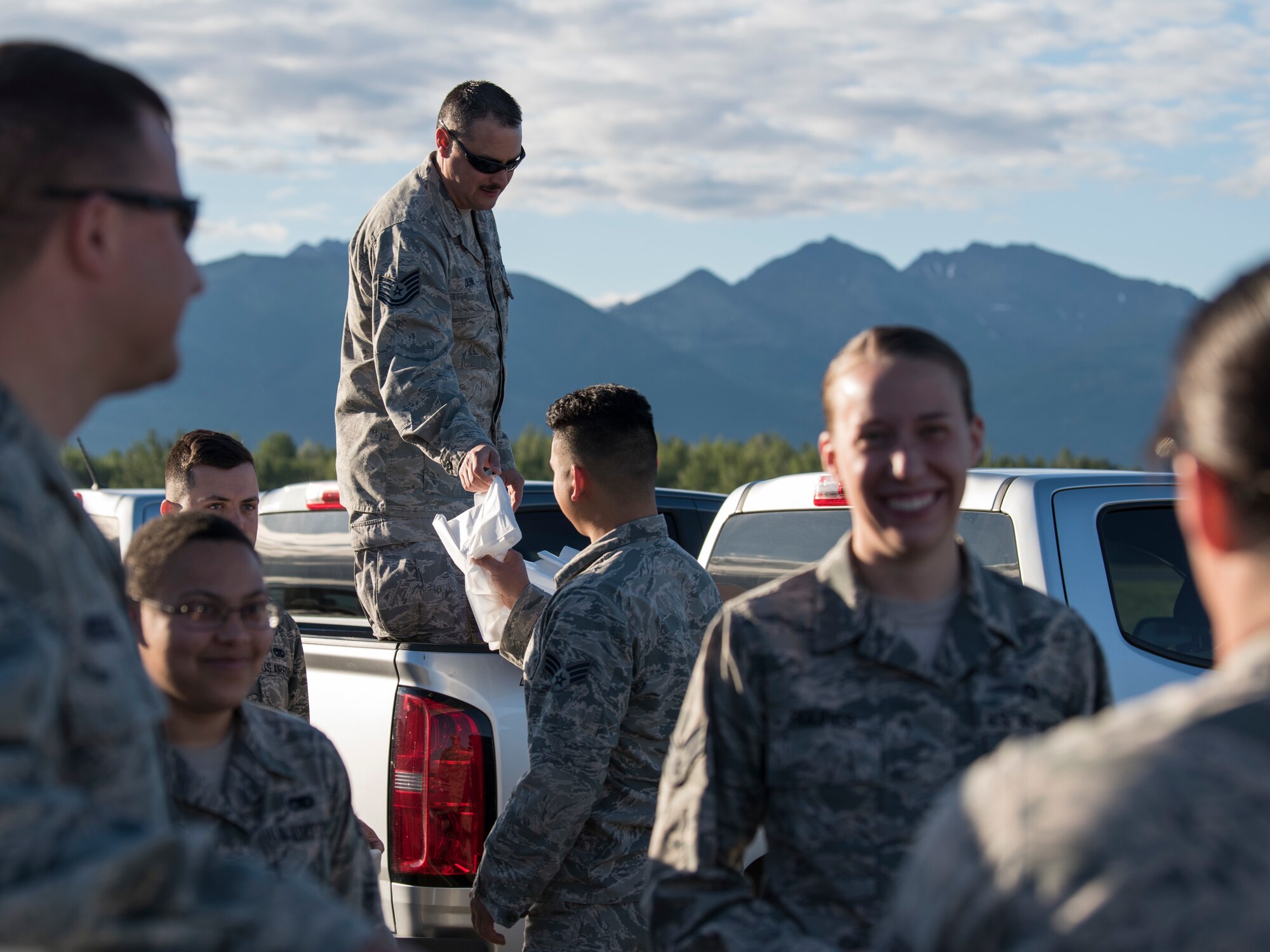 Tech. Sgt. Hayden Dunn, a 3rd Munitions Squadron production flight supervisor, hands active-duty Airmen trash bags as they prepare to conduct a foreign object and debris walk at Joint Base Elmendorf-Richardson, Alaska, July 2, 2018. The JBER Airmen conducted the FOD walk after the Arctic Thunder Open House to remove debris that could damage aircraft and hinder mission readiness.