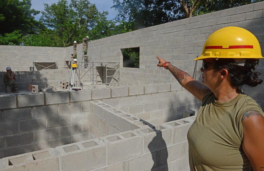 Staff Sgt. Cristin Baughman is the non-commissioned officer in charge of a group of 30 Soldiers from the 4th Engineer Battalion, Fort Carson, Colorado, directs construction of a three-classroom cinderblock structure for elementary and middle school children at Santa Rita, El Salvador, June 25, 2018, in La Paz Department, El Salvador.