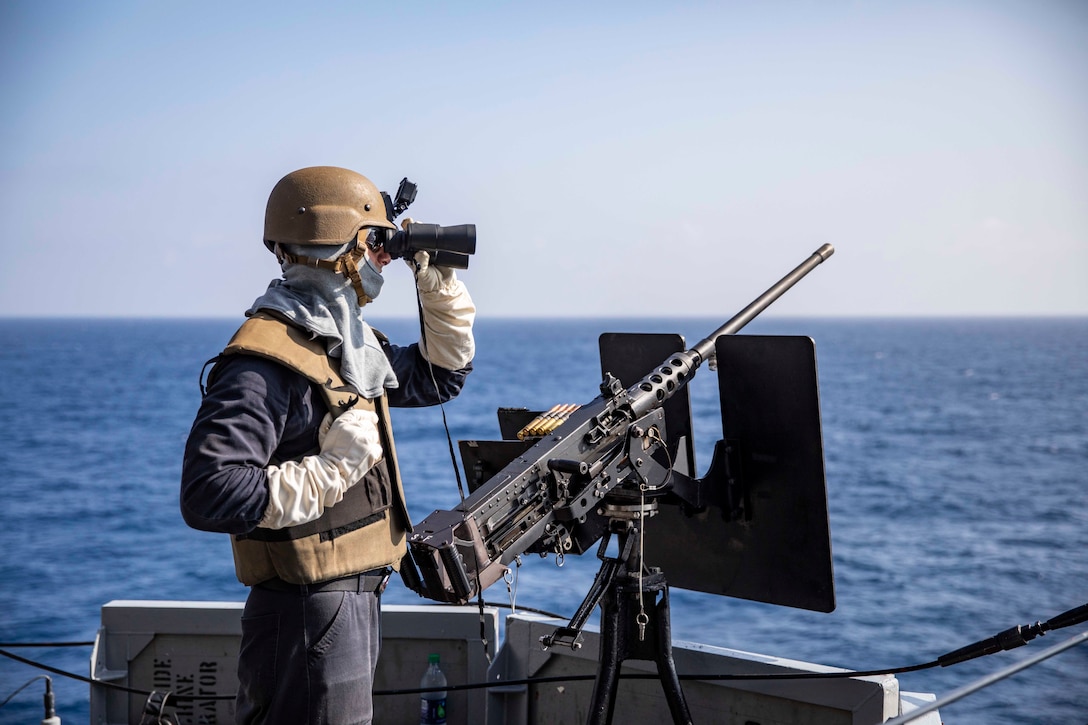 A sailor scans for surface contacts during an integrated live-fire weapons exercise.