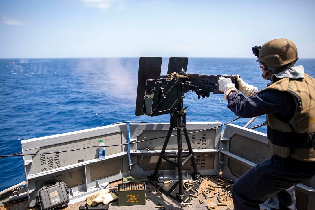 A sailor fires a .50-caliber machine gun during an integrated live-fire weapons exercise.
