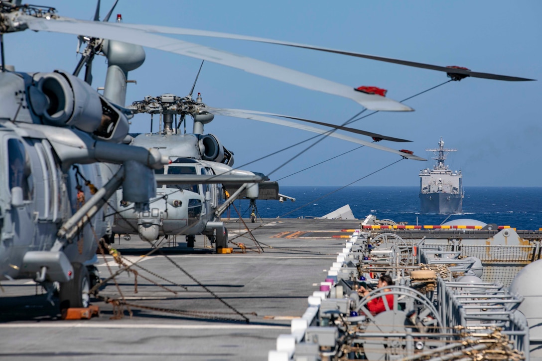 The USS Fort McHenry steams behind the amphibious assault ship USS Kearsarge.