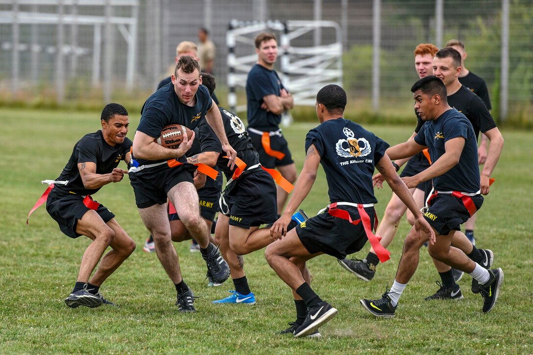 A group of soldiers play flag football.