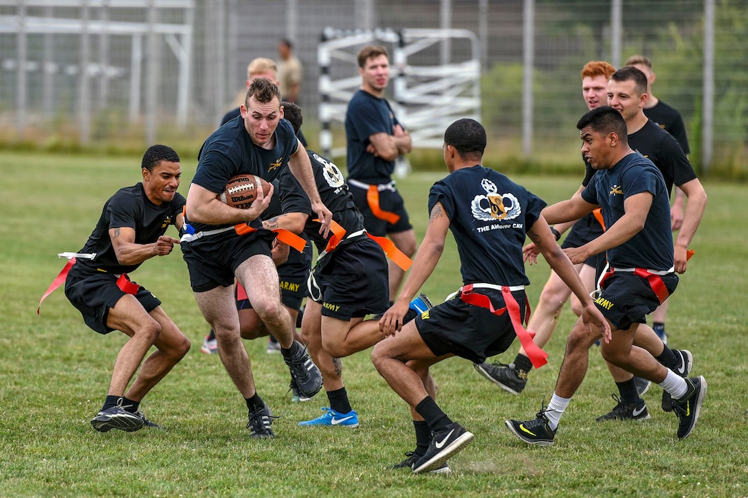 A group of soldiers play flag football.