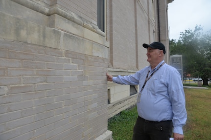 Alan White, 502nd Civil Engineering Squadron, architect/cultural resource manager at Joint Base San Antonio-Fort Sam Houston, inspects a section of brick and limestone at the back of the historic Main Post Chapel, at JBSA-Fort Sam Houston, that was cleaned in late April using a steam cleaning method. The exterior of the chapel was cleaned to get rid of dirt, pollution, organic material and a black mold that had formed and accumulated overtime on the masonry of the building. The cleaning of the Main Post Chapel, also known as the Gift Chapel, was conducted following guidelines for the cleaning of historic masonry buildings by the U.S. Department of Interior and the National Park Service.