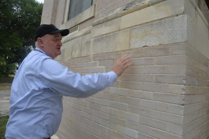 Alan White, 502nd Civil Engineering Squadron, architect/cultural resource manager at Joint Base San Antonio-Fort Sam Houston, inspects a section of brick and limestone at the back of the historic Main Post Chapel, at JBSA-Fort Sam Houston, that was cleaned in late April using a steam cleaning method. The exterior of the chapel was cleaned to get rid of dirt, pollution, organic material and a black mold that had formed and accumulated overtime on the masonry of the building. The cleaning of the Main Post Chapel, also known as the Gift Chapel, was conducted following guidelines for the cleaning of historic masonry buildings by the U.S. Department of Interior and the National Park Service.