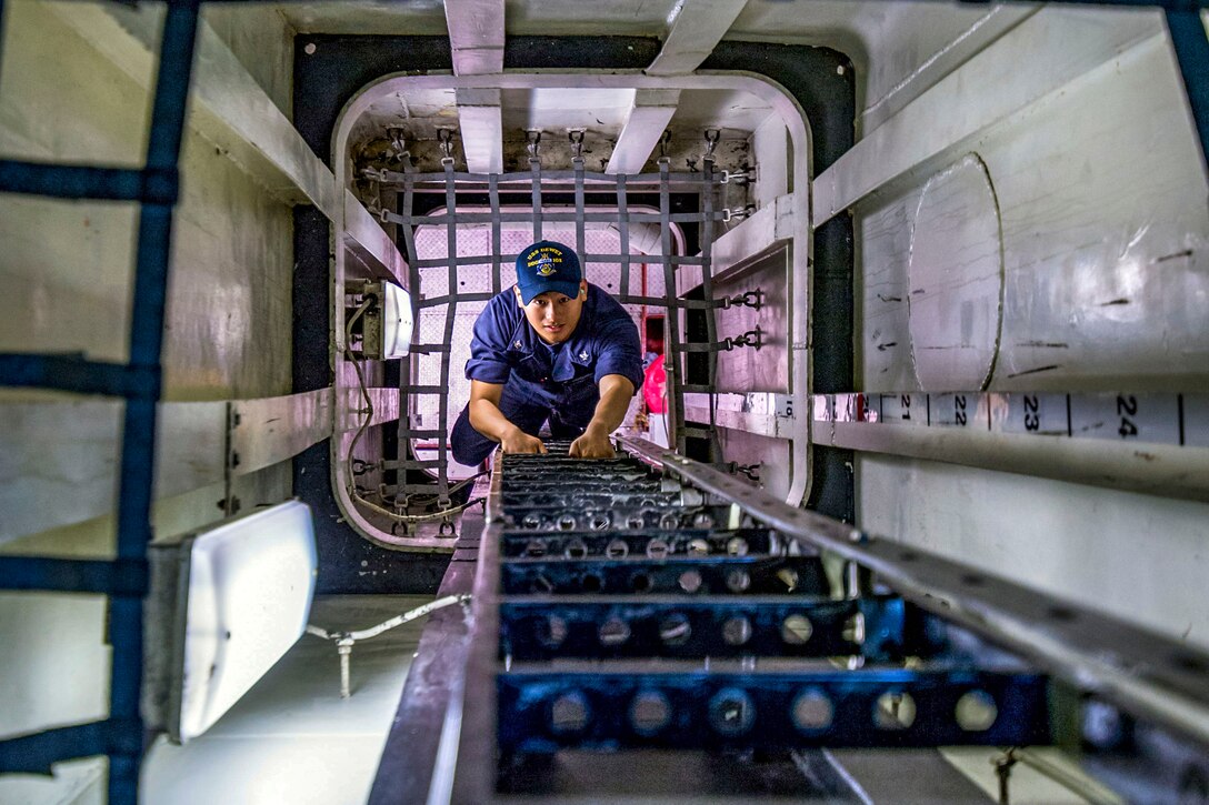 A sailor climbs a ladder.