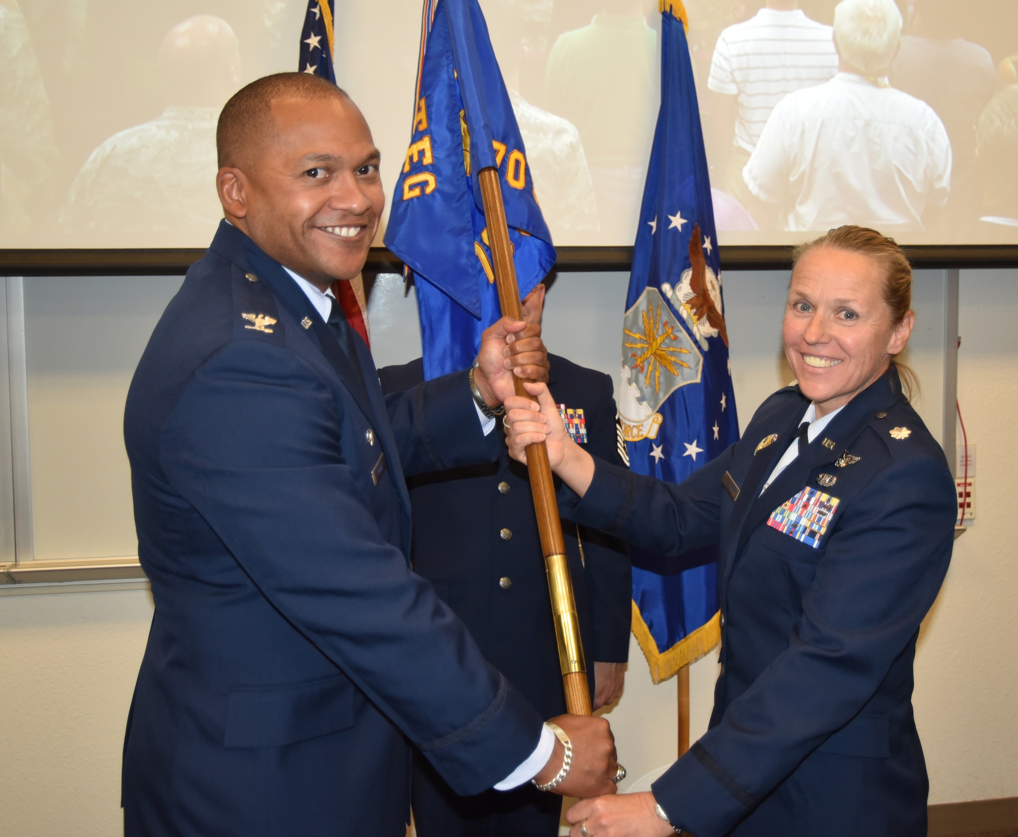 Lt. Col. Angela Messing is one of three new squadron commanders to assume command at Kirtland in June.  Here, Messing (right) takes the 705th Combat Training Squadron guidon from Col. Jon Rhone, 505th Test and Evaluation commander, during a ceremony June 29.