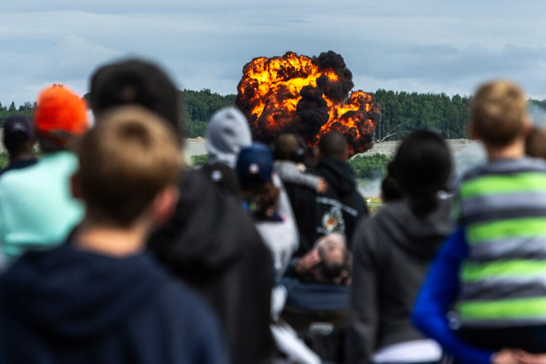 The crowd watches a fireball caused by an explosion.