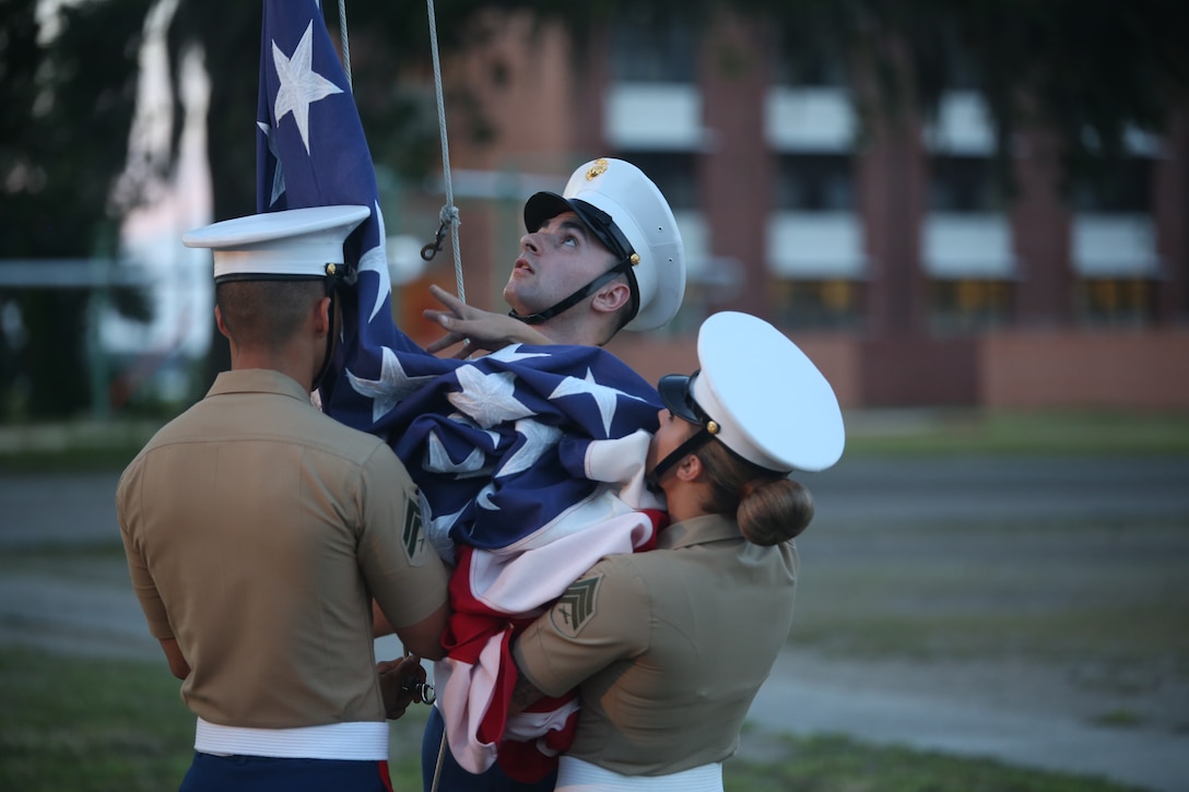 Marines conduct evening colors during an Independence Day celebration aboard Marine Corps Recruit Depot Parris Island July 4. The national ensign is a physical representation of the country. It is a service wide custom to display the colors from sunrise to sunset.