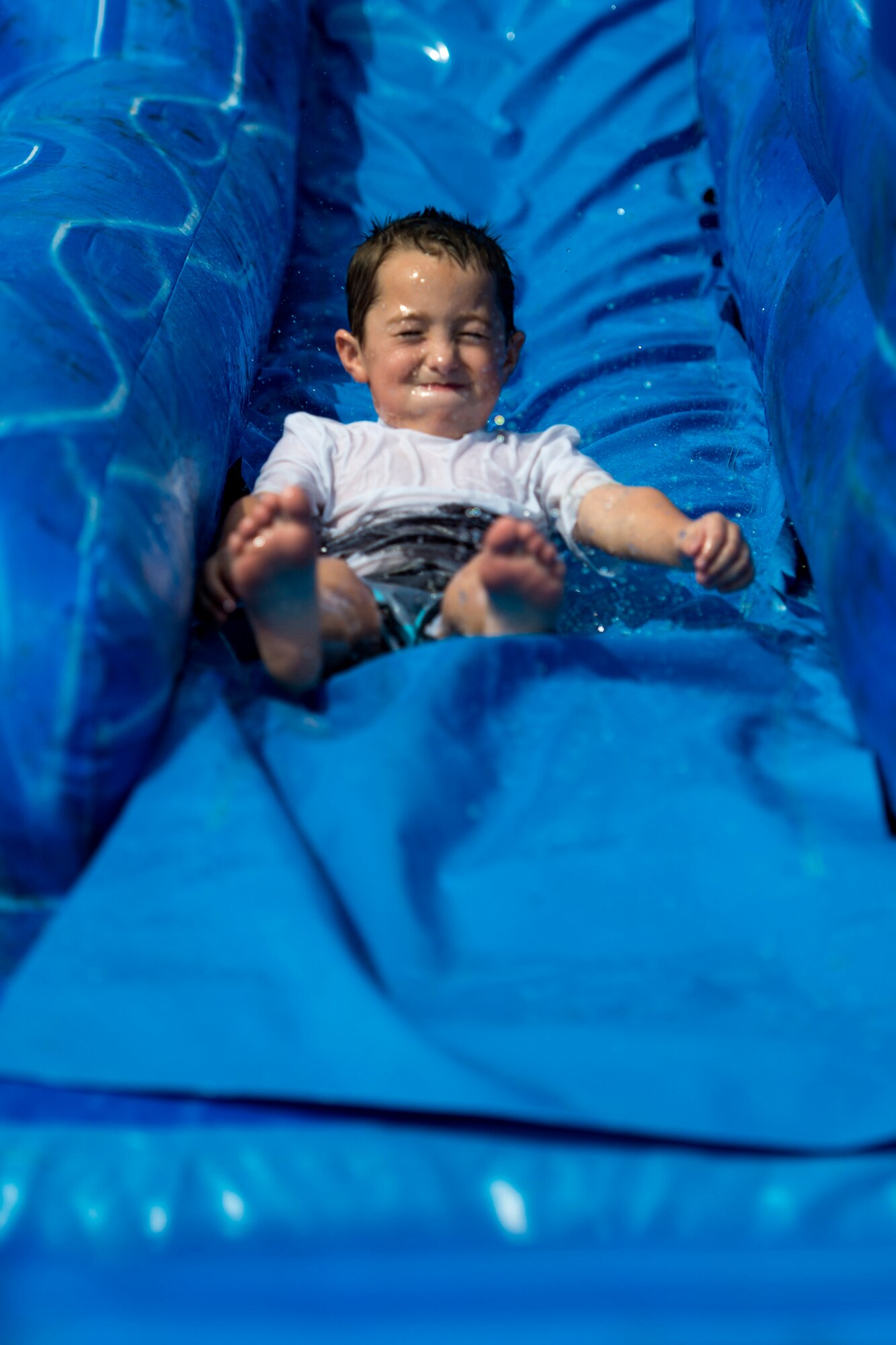 A participant goes down a water slide during the Patriot Festival, July 3, 2018, at Moody Air Force Base, Ga. Team Moody hosted the free event to allow Airmen and their families an opportunity to take some time away from the mission and enjoy a Fourth of July experience. The event consisted of live music, food trucks, family fun and a firework show. (U.S. Air Force photo by Airman 1st Class Erick Requadt)
