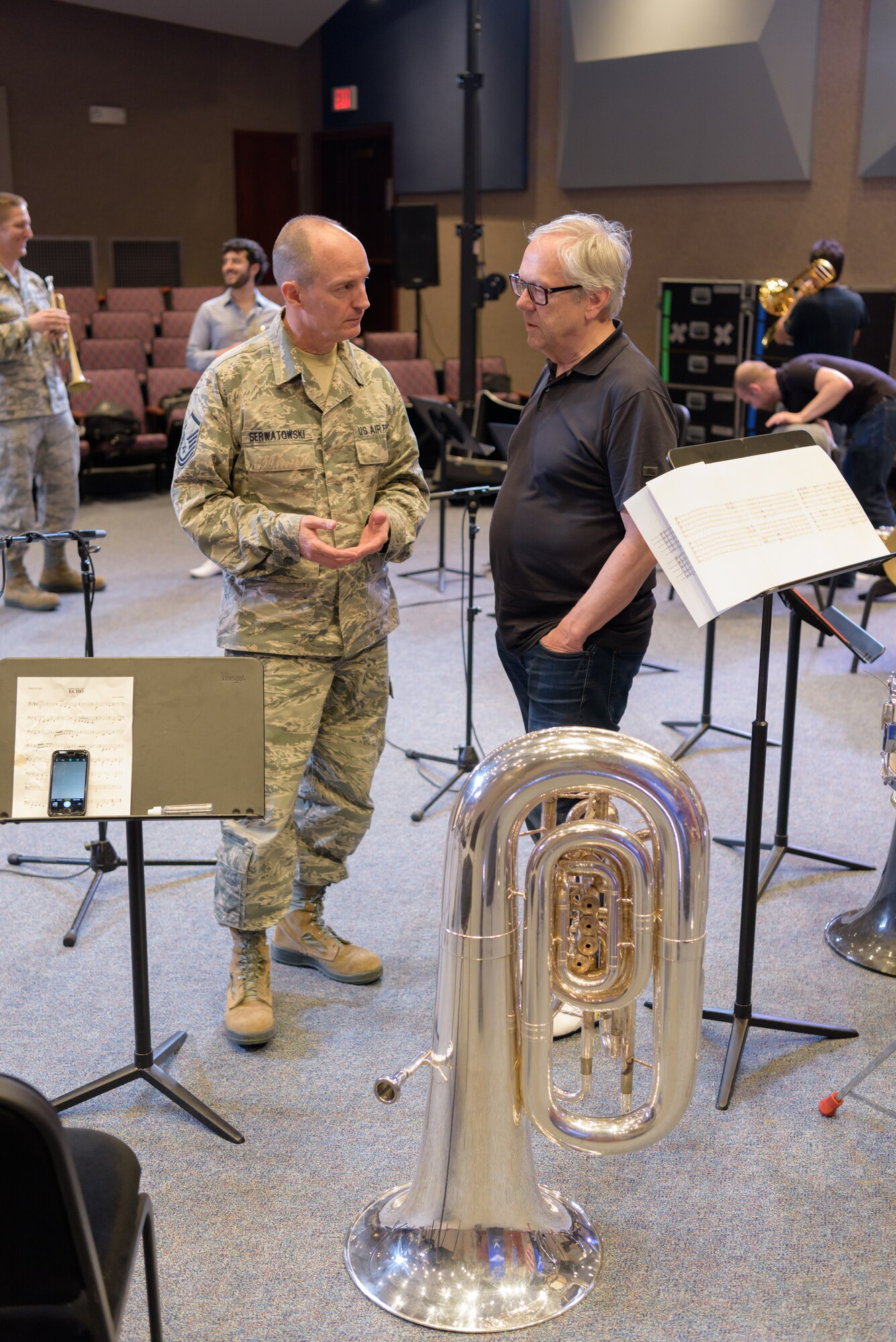 U.S. Air Force Master Sgt. Alex Serwatowski, Heartland of America Band section chief of publicity and tuba player, and Chuck Daellenbach, Canadian Brass tuba player, speak before their collaborative rehearsal June 8, 2018, at Offutt Air Force Base, Nebraska. Canadian Brass, formed in 1970, has won Juno, Grammy and Echo awards and is considered to be one of the most successful brass ensembles in the world. (U.S. Air Force photo by Senior Airman Jacob Skovo)