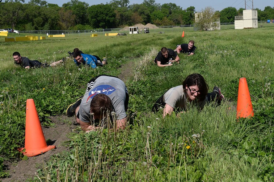 Members of the 55th Security Forces Squadron low crawl during an evasion challenge May 17, 2018, at Offutt Air Force Base, Nebraska. Offutt’s defenders participated in local events as well as coordinating base events to recognize the contributions of police across the nation. (U.S. Air Force photo by Charles J. Haymond)