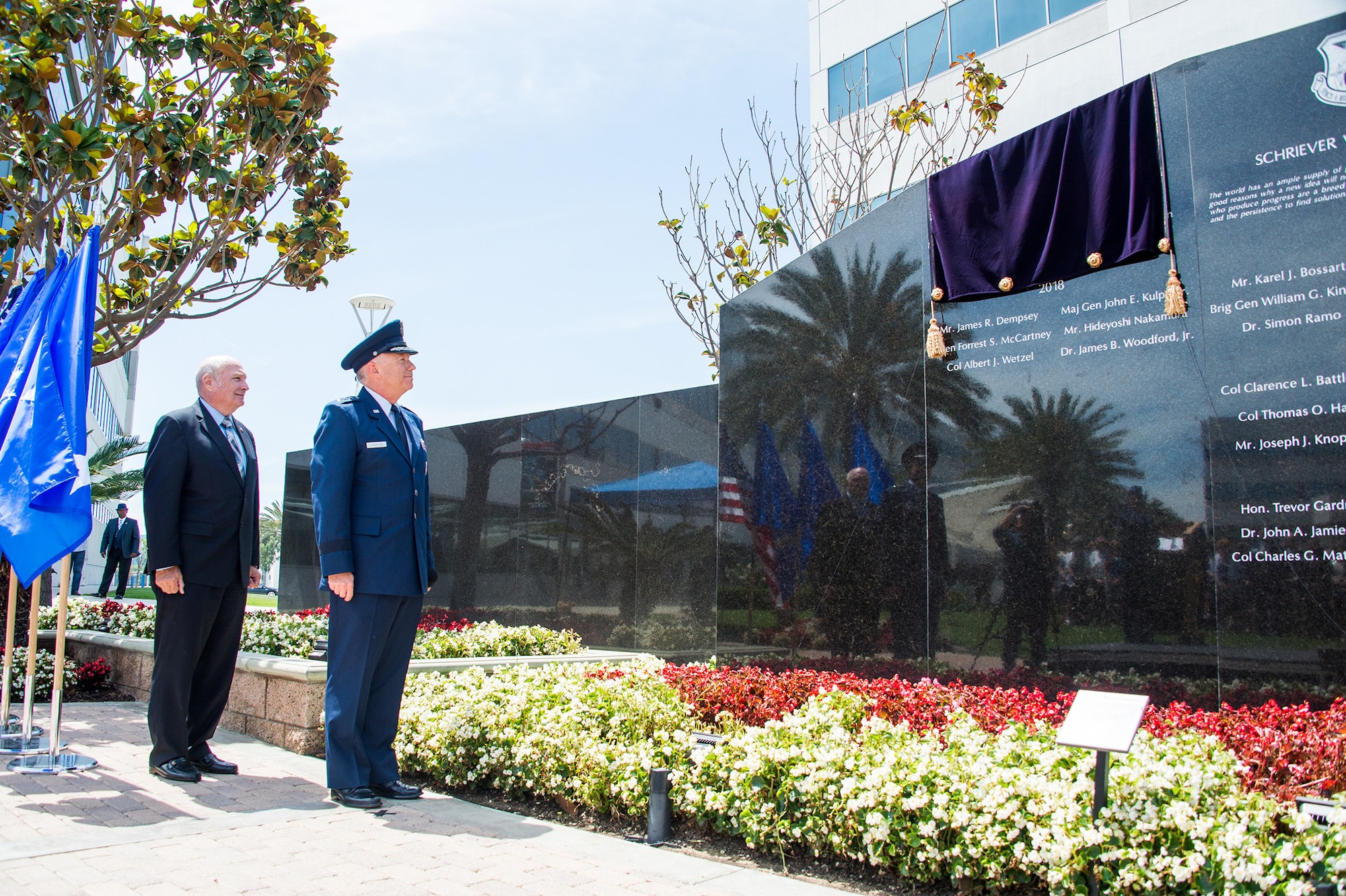 Lt. Gen. John Thompson, commander of the Space and Missile Systems Center, and retired Maj. Gen. Thomas Taverney, chairman of the board of the Schriever chapter of the Air Force Association and former vice commander of Air Force Space Command, watch as six newly inscribed names of Air Force and civilian space pioneers are revealed during the 2018 Schriever Wall of Honor induction ceremony at Los Angeles Air Force Base in El Segundo, California, May 14, 2018. (U.S. Air Force photo/Van De Ha)