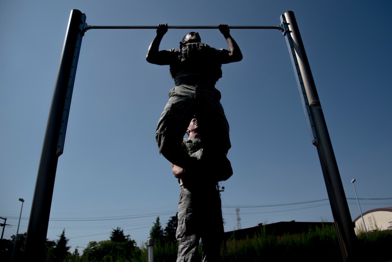 Senior Airman Antonio Gant, 374th Security Forces Squadron 2018 Security Forces Advanced Combat Skills Assessment team member, does pull ups in bullet proof vest during group physical training, June 1, 2018, at Yokota Air Base, Japan.