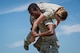 Senior Airman Antonio Gant, 374th Security Forces Squadron 2018 Security Forces Advanced Combat Skills Assessment team member, fireman carries fellow team member, Airman 1st Class, Hanna Barnes, during group physical training, June 1, 2018, at Yokota Air Base, Japan.
