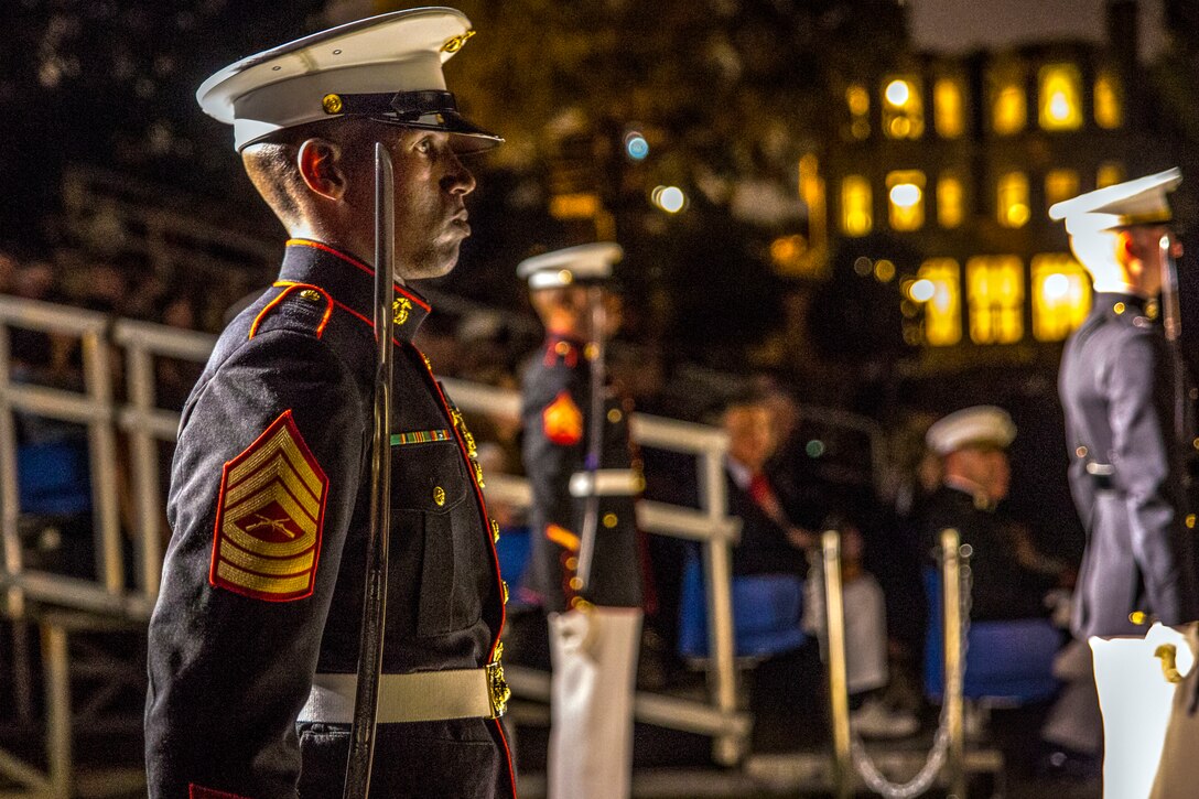Marines stand holding weapons during a ceremony.