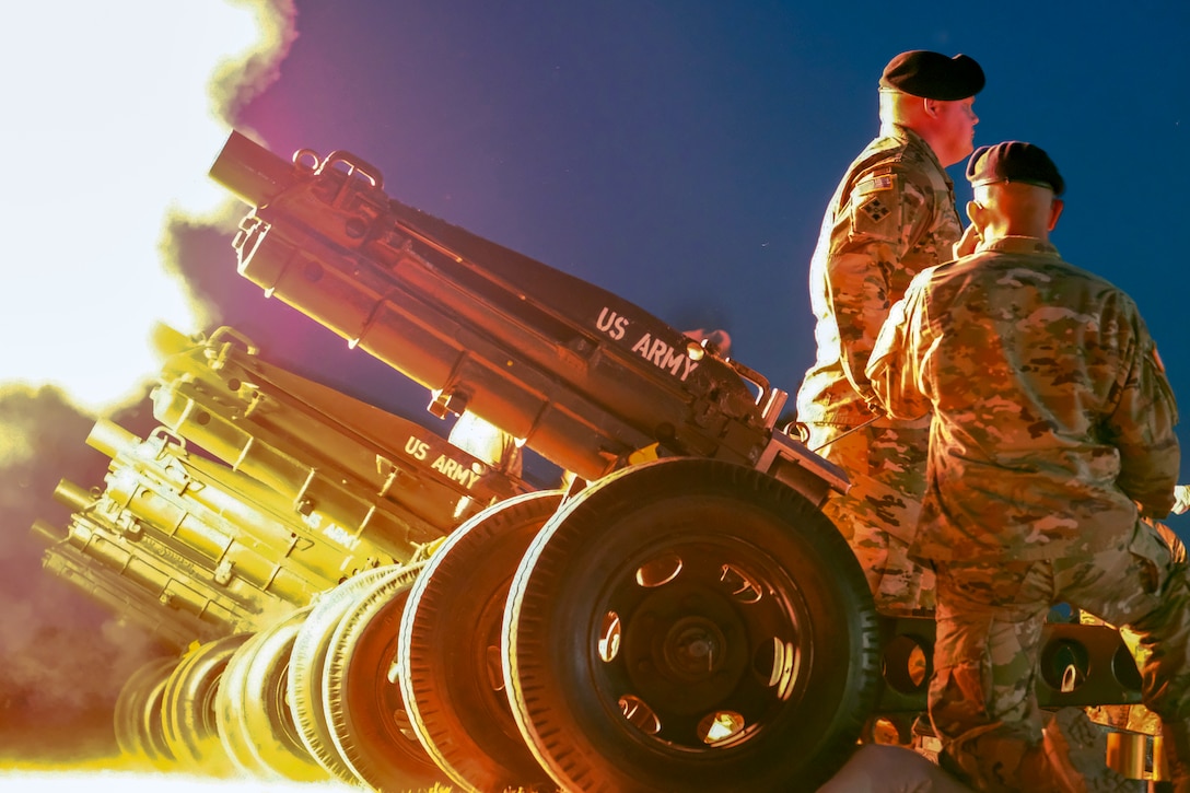 Soldiers fire artillery.