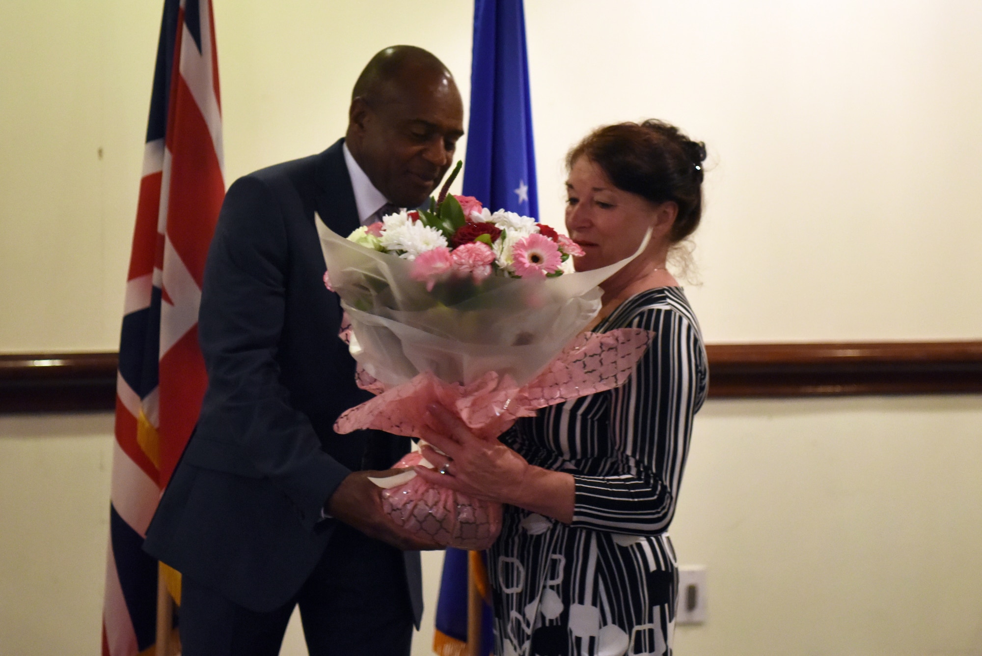 Mr. Edward Cole, 48th Fighter Wing community support director, gives flowers to his wife Marilyn Cole during Cole’s retirement ceremony at Royal Air Force Lakenheath, England, June 29, 2018. They met while both were working at the now-closed RAF Chicksands, England. (U.S. Air Force photo/ Airman 1st Class John A. Crawford)