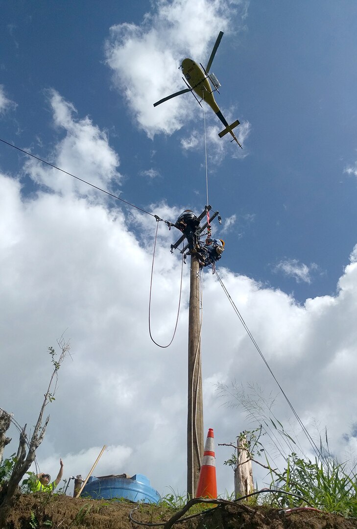 The U.S. Army Corps of Engineers uses helicopters to place poles and electrical power lines in the mountain community of San German, Puerto Rico, in February.
