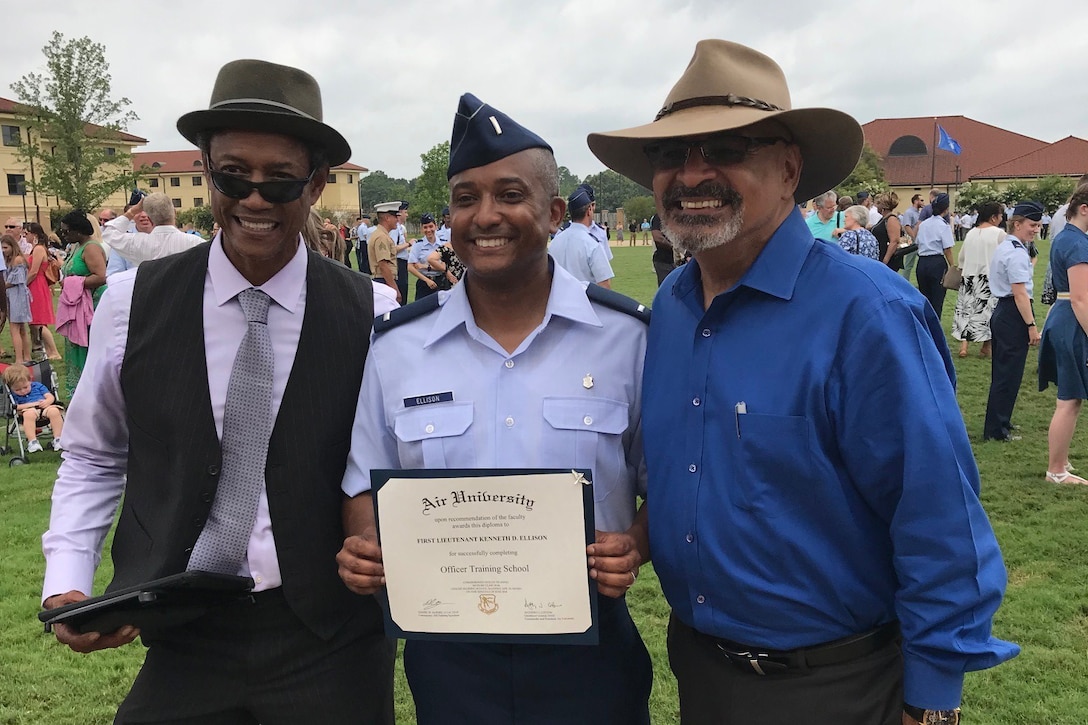 Three men pose for a picture.