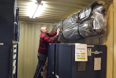 Christopher Jenkins, material support specialist, Storage and Distribution Division, DLA Aviation at Ogden, Utah, secures material in a container in preparation for transportation. The container is part of a build set of material supporting Intercontinental Ballistic Missile program depot maintenance for Air Force launch facilities.