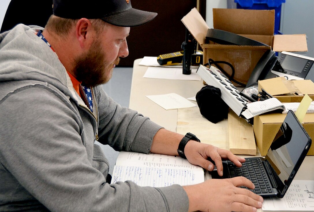 Phillip Fitz, a heating, ventilating and air conditioning controls mechanic, inputs data using a computer tablet instead of writing it in a notebook. The Installation Management Division is implementing a plan that issues employees in the field computer tablets to access information and input critical data for greater efficiency and timeliness.