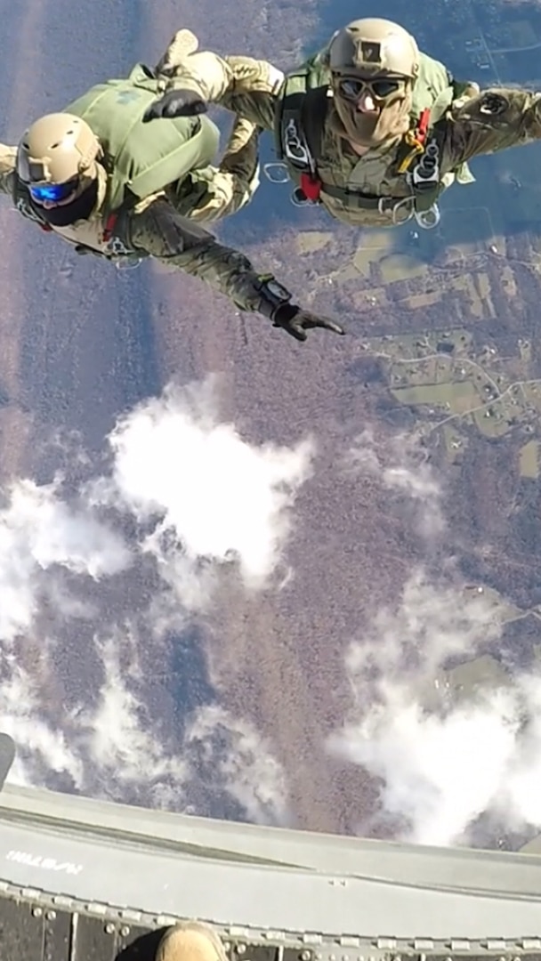 Army Staff Sgts. Brandon Guevara and Matthew Rosenkranz maintain their jump status as they exit a CH-47 Chinook cargo helicopter from 12,500 feet.