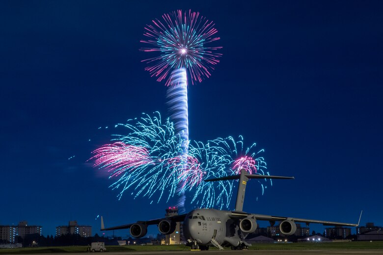 Fireworks explode behind a U.S. Air Force C-17 Globemaster III aircraft assigned to the 15th Wing during Celebrate America, July 3, 2018, at Yokota Air Base, Japan. Celebrate America is an annual event that provides military members and their families the opportunity to enjoy games, food and bands before culminating in a fireworks display over the Yokota AB airfield to celebrate Independence Day. (U.S. Air Force photo by Yasuo Osakabe)