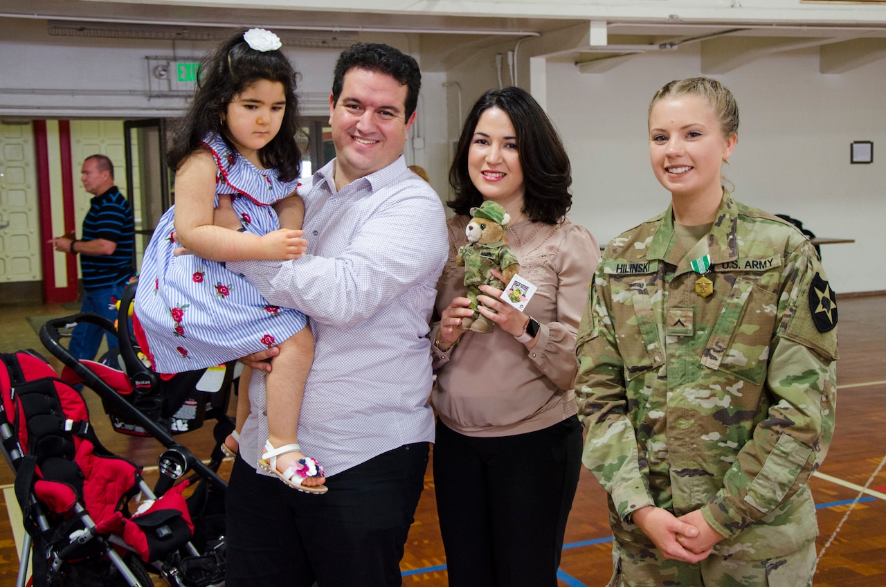 Pvt. Gracie Hilinski, Medical Section, Headquarters and Headquarters Battery, 2nd Battalion, 146th Field Artillery Regiment, 81st Stryker Brigade Combat Team poses with (from left to right) Lilya Soulami, Ayoub Soulami, and Asmae Hram, little girl, and her family, whose life was saved by Hilinski, at a ceremony at the National Guard Armory in Olympia, Wash., June 30, 2018.