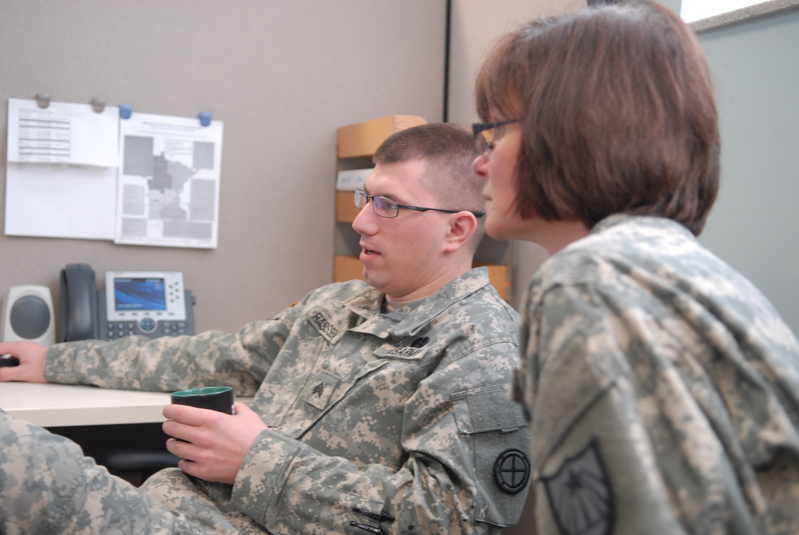 GI Bill Manager Sgt. Eric Rasmussen and Federal Tuition Assistance Manager Sgt. 1st Class Teresa Anthony discuss education benefits in the Minnesota National Guard's Education Office in Saint Paul, Minn.