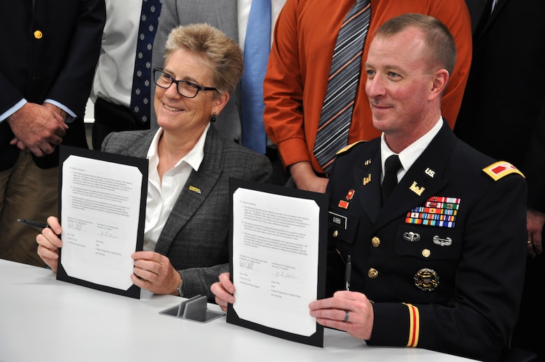 Dr. Emily Allen, dean of the College of Engineering, Computer Science and Technology, California State University, Los Angeles, and Col. Kirk Gibbs, commander of the U.S. Army Corps of Engineers Los Angeles District, sign a partnering agreement July 5 in Los Angeles, California, to foster collaboration in a relationship that stresses the importance of Science, Technology, Engineering and Mathematics as officials from the university and the Corps look on. The agreement also provides a road map to employment with the Corps through various programs, including the Pathways internship program.