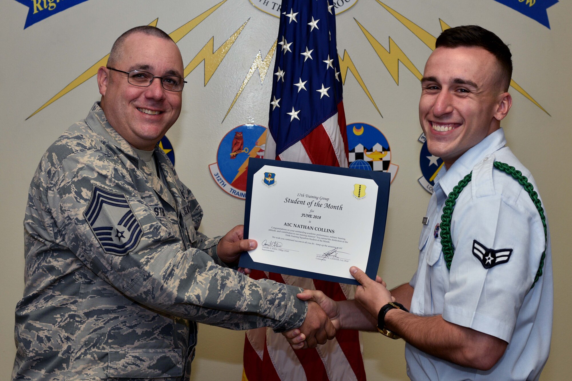 U.S. Air Force Chief Master Sgt. Daniel Stein, 17th Training Group superintendent, presents the 316th Training Squadron Student of the Month award to Airman 1st Class Nathan Collin, 316th TRS trainee, at Brandenburg Hall on Goodfellow Air Force Base, Texas, July 6, 2018. The 316th TRS’s mission is to conduct U.S. Air Force, U.S. Army, U.S. Marine Corps, U.S. Navy and U.S. Coast Guard cryptologic, human intelligence and military training. (U.S. Air Force photo by Senior Airman Randall Moose/Released)