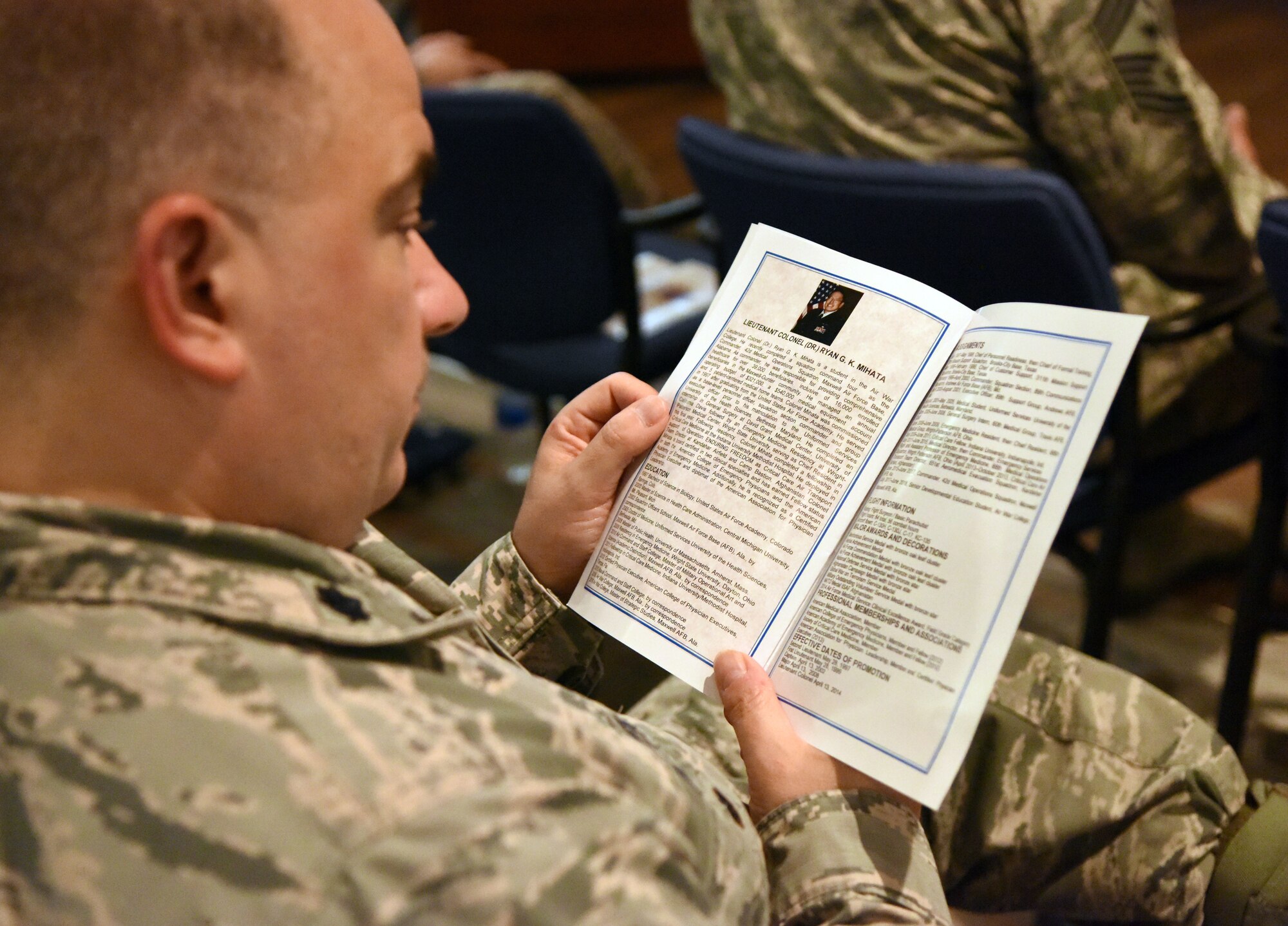 U.S. Air Force Lt. Col. Paul Fidler, 81st Mission Support Group deputy commander, reads an event program during the 81st Surgical Operations Squadron assumption of command ceremony at the Keesler Medical Center on Keesler Air Force Base, Mississippi, July 2, 2018.  The passing of the guidon is a ceremonial symbol of exchanging command from one commander to another. Lt. Col. Ryan Mihata, incoming 81st MSGS commander, assumed command during the ceremony. (U.S. Air Force photo by Kemberly Groue)