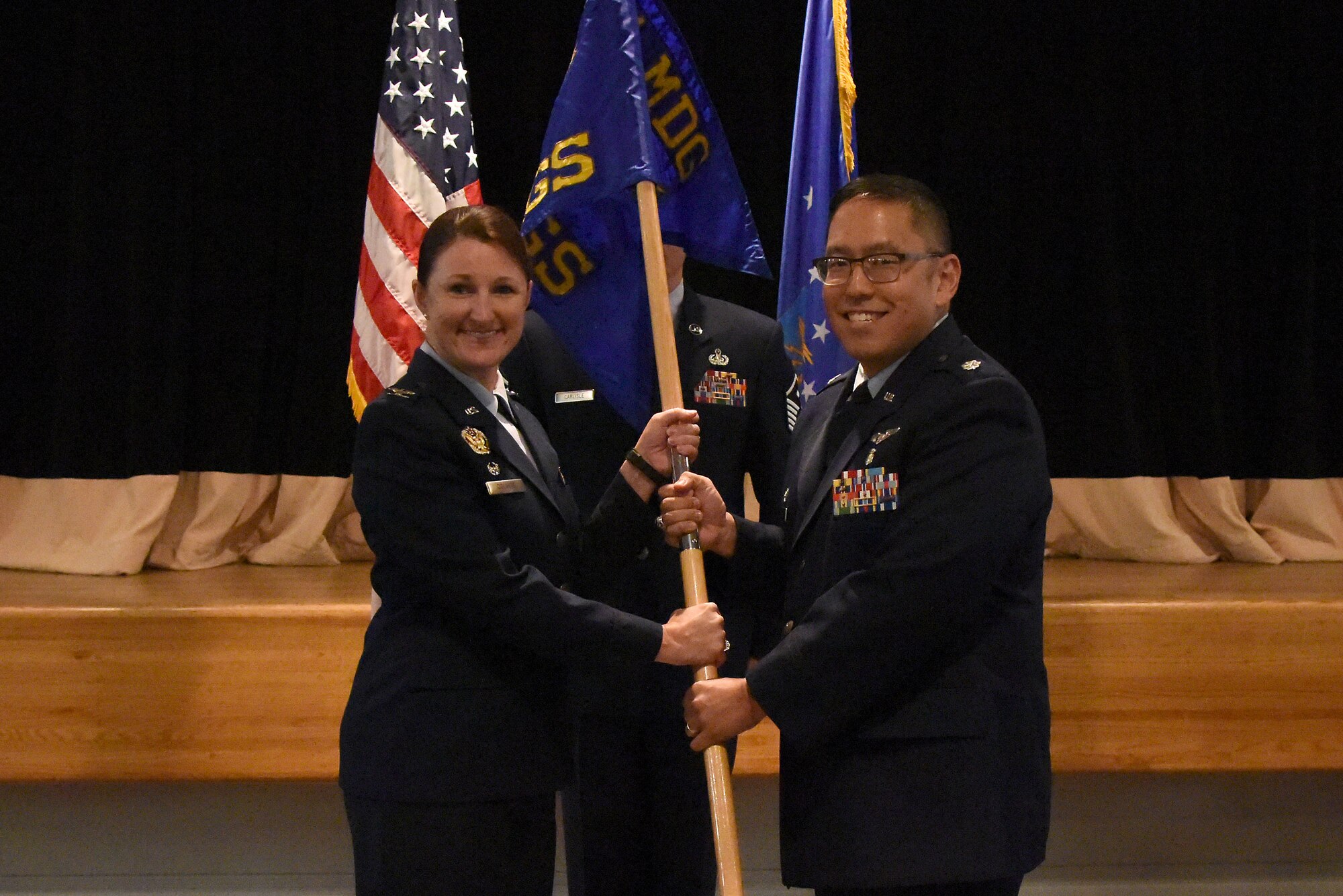 U.S. Air Force Col. Beatrice Dolihite, 81st Medical Group commander, passes the 81st Surgical Operations Squadron guidon to Lt. Col. Ryan Mihata, 81st MSGS commander, during the 81st MSGS assumption of command ceremony at the Keesler Medical Center on Keesler Air Force Base, Mississippi, July 2, 2018. The passing of the guidon is a ceremonial symbol of exchanging command from one commander to another. (U.S. Air Force photo by Kemberly Groue)