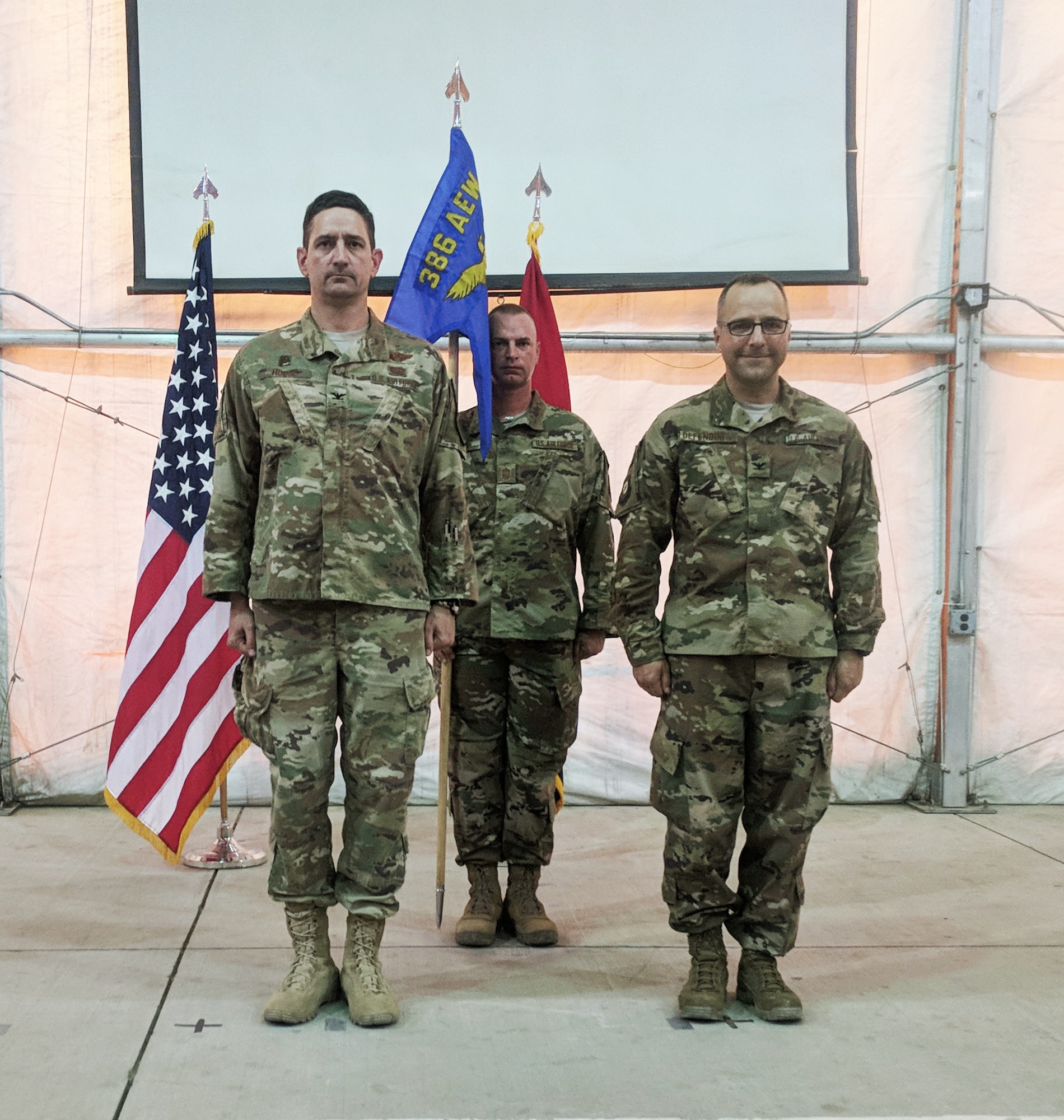 Col. Stephen Hodge, the Commander of the 386th Air Expeditionary Wing, Chief Todd, Command Chief of the 370th Air Expeditionary Advisory Group, and Col. Eduardo Defendini, Commander of the 370th AEAG, stand at attention during the assumption of command ceremony in Baghdad, Iraq, July 5. Defendini was previously assigned as the chief of NATO Alliance Ground Forces Operations in Belgium. (Courtesy photo)