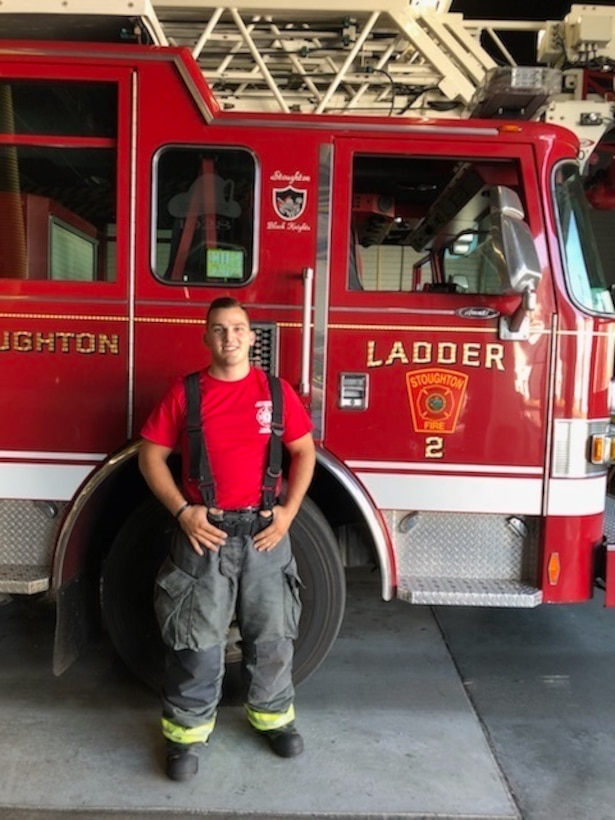 Cpl. Joseph R. Manganaro, a Marine Corps Reserve mortarman and forward observer with 1st Battalion, 25th Marine Regiment, 4th Marine Division, poses by a firetruck while on duty as a firefighter and paramedic with the Stoughton Fire Department in Stoughton, Massachusetts, June 29, 2018. On June 13, 2018, Manganaro was on his way to Marine Corps Air Ground Combat Center Twentynine Palms to conduct training with his unit at Integrated Training Exercise 4-18, when he provided critical emergency medical care to a passenger aboard an American Airlines flight.