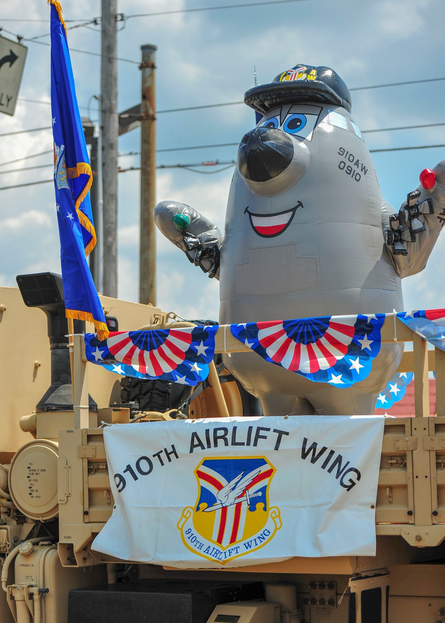 Winger, a caricature of a C-130H Hercules aircraft that serves as the 910th Airlift Wing's mascot, waves to the crowd during a Fourth of July parade in Austintown, Ohio.