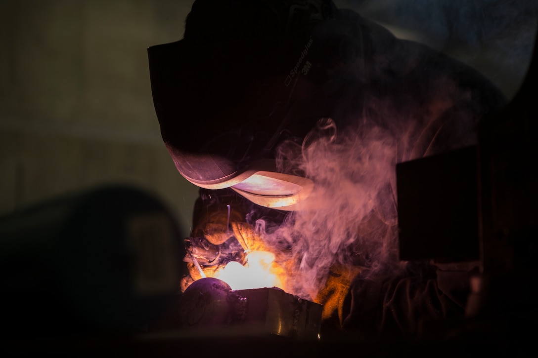 Lance Cpl. Christopher Alcazar, a welder with General Support Maintenance Company, 3rd Maintenance Battalion, Combat Logistics Regiment 35, 3rd Marine Logistics Group, welds a piece of scrap metal while practicing metalworking July 9, 2018 at Camp Kinser, Okinawa, Japan. GSM Co. is the largest Marine Corps metalworking shop in the Indo-Pacific region, providing III Marine Expeditionary Force with capabilities to manufacture a multitude of parts and components. Alcazar is a native of South El Monte, California.
